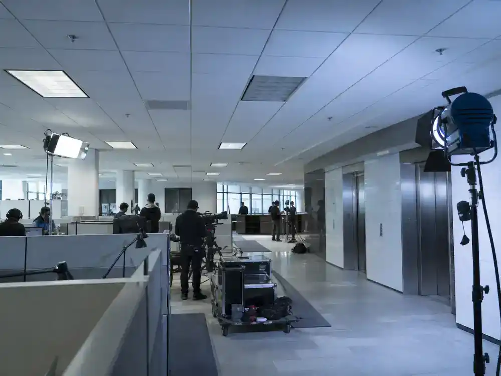 Severance season 2 cast and plot guide Lumon office — expansive sterile corporate floor film set with cubicles and elevator bank, editorial production reference