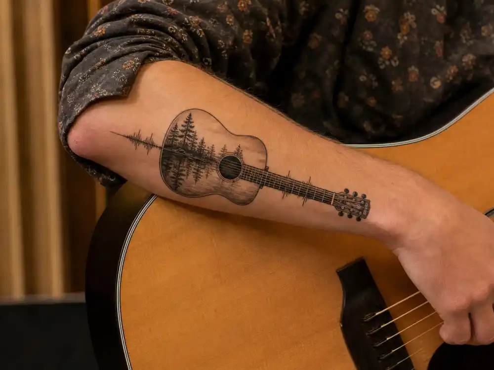 Shawn Mendes tattoos and their meanings — first guitar forearm tattoo with tree lake reflection and parents voice tribute 2016