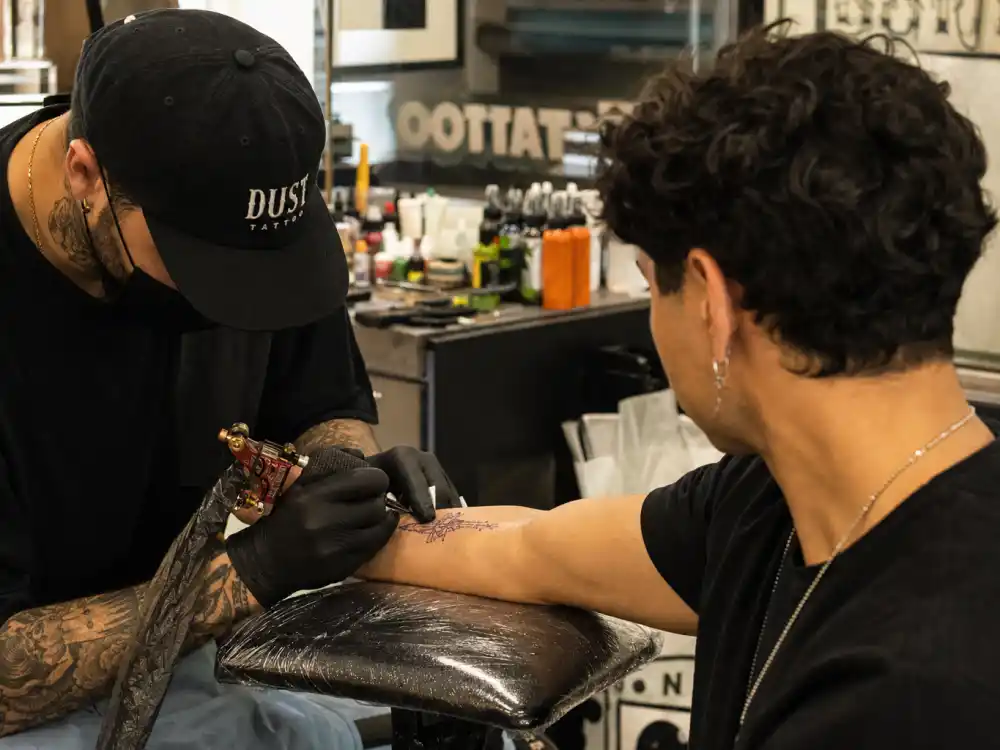 Shawn Mendes tattoos and their meanings — Kane Navasard LA tattoo studio session with single needle machine on client forearm