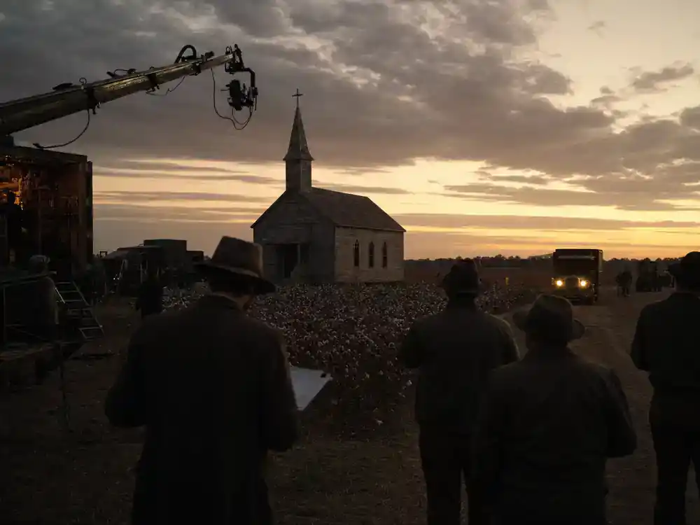 Sinners movie cast and Ryan Coogler guide Mississippi Delta filming — crew scouting Southern countryside location at dusk with film trucks and crane