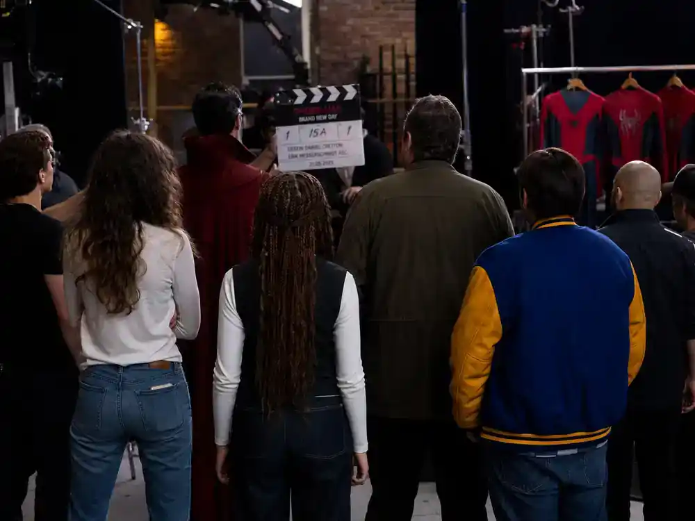 Spider-Man Brand New Day cast and characters guide MCU returning cast — ensemble silhouettes on superhero film set from behind with costume rack