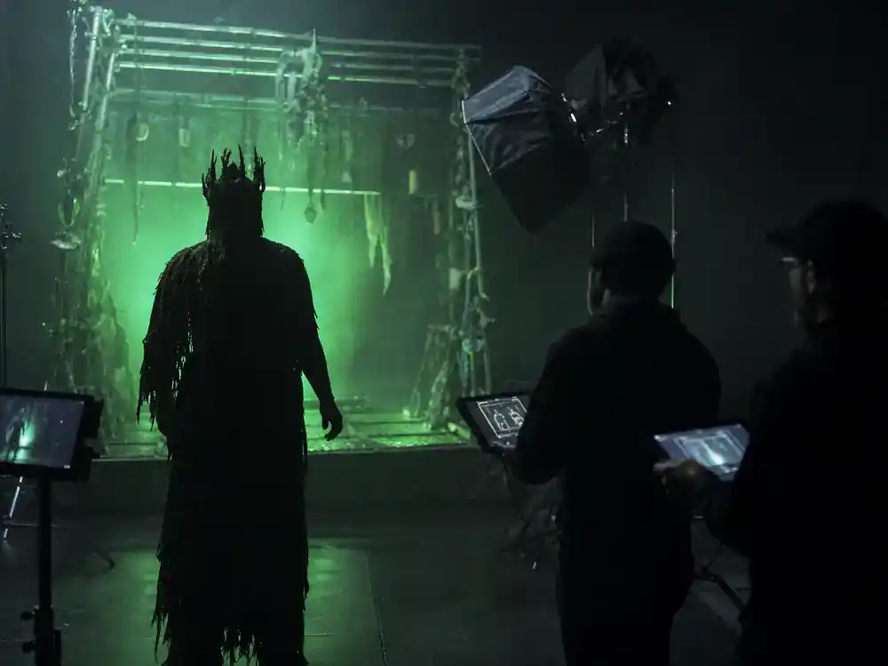 Stranger Things season 5 cast and characters guide Vecna — performer silhouette in tattered costume on dark soundstage during supernatural villain scene blocking