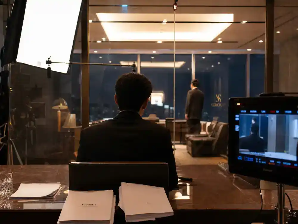 Succession cast and characters guide Kendall Roy — heir actor silhouette from behind rehearsing emotional scene at glass office TV drama film set
