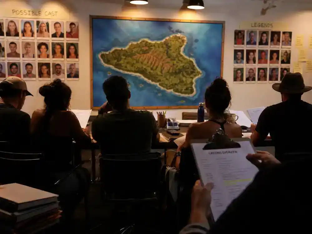 Survivor 50 cast and season preview guide legends — returning cast silhouettes at tropical island casting table with production clipboard