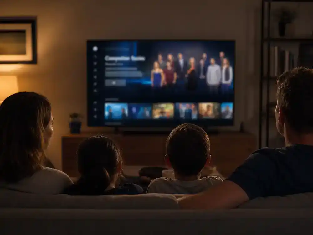 Survivor 50 cast and season preview guide Paramount Plus — family silhouettes watching CBS reality competition on living room TV with generic streaming interface