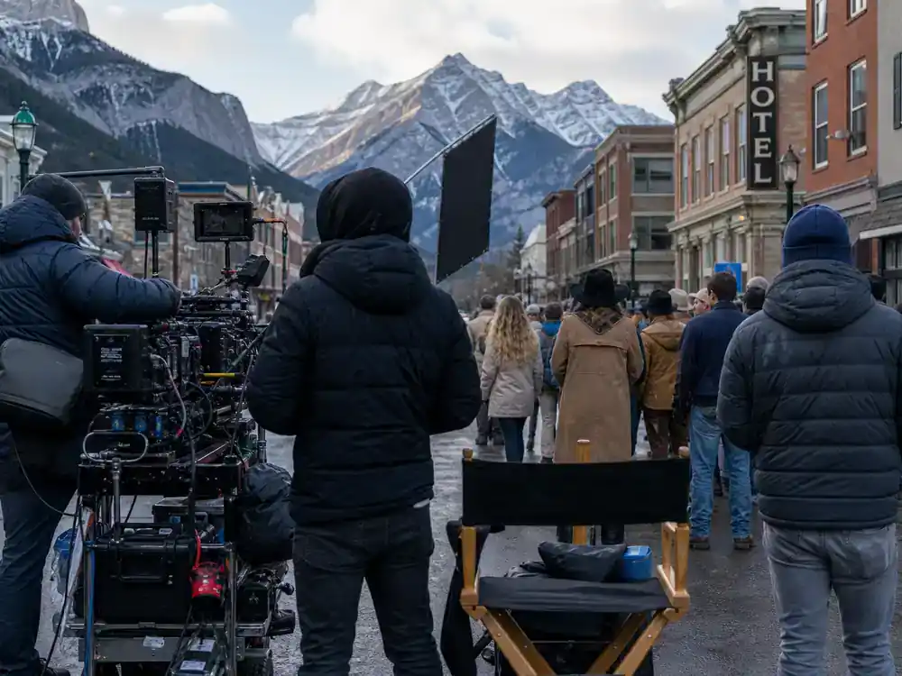The Last of Us behind the scenes filming facts Alberta Jackson location — crew filming on mountain town main street with Rockies backdrop and director chair