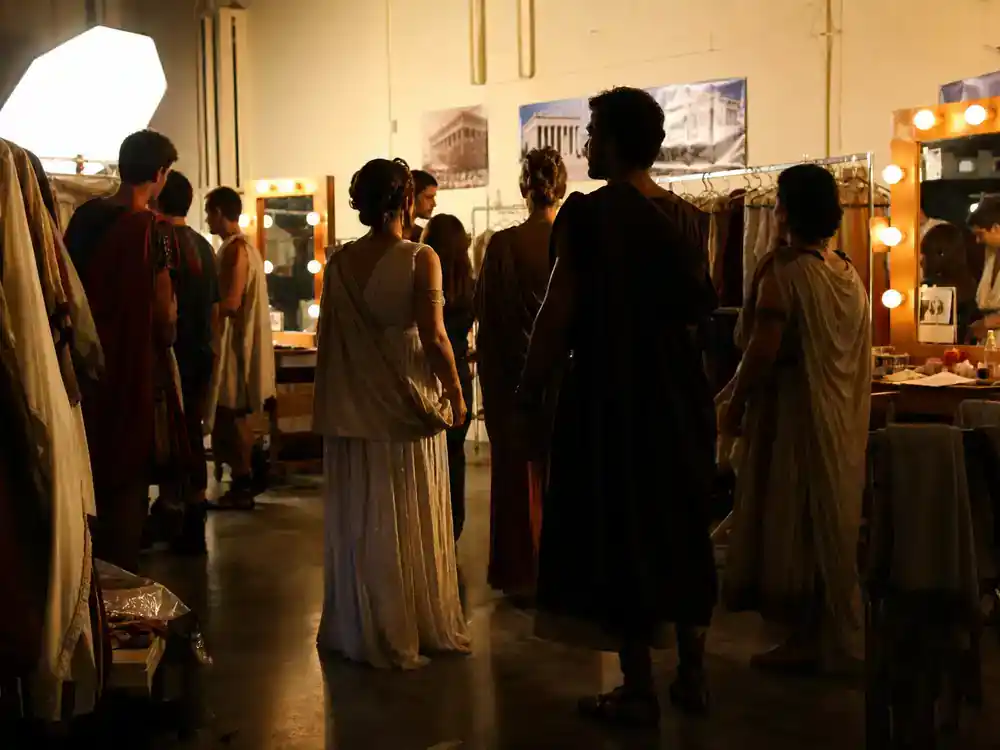 The Odyssey 2026 movie cast and plot explained ensemble cast — premiere silhouettes walking red carpet toward theater marquee from behind