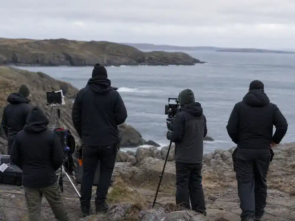 The Odyssey 2026 movie cast and plot explained filming — IMAX 70mm camera on ancient Greek ruins set with crew adjusting production lighting