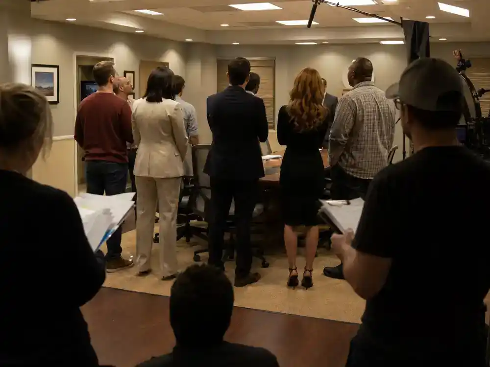 The Office cast net worth 2026 ranked ensemble syndication — cast silhouettes in conference room on office TV set with crew clipboards