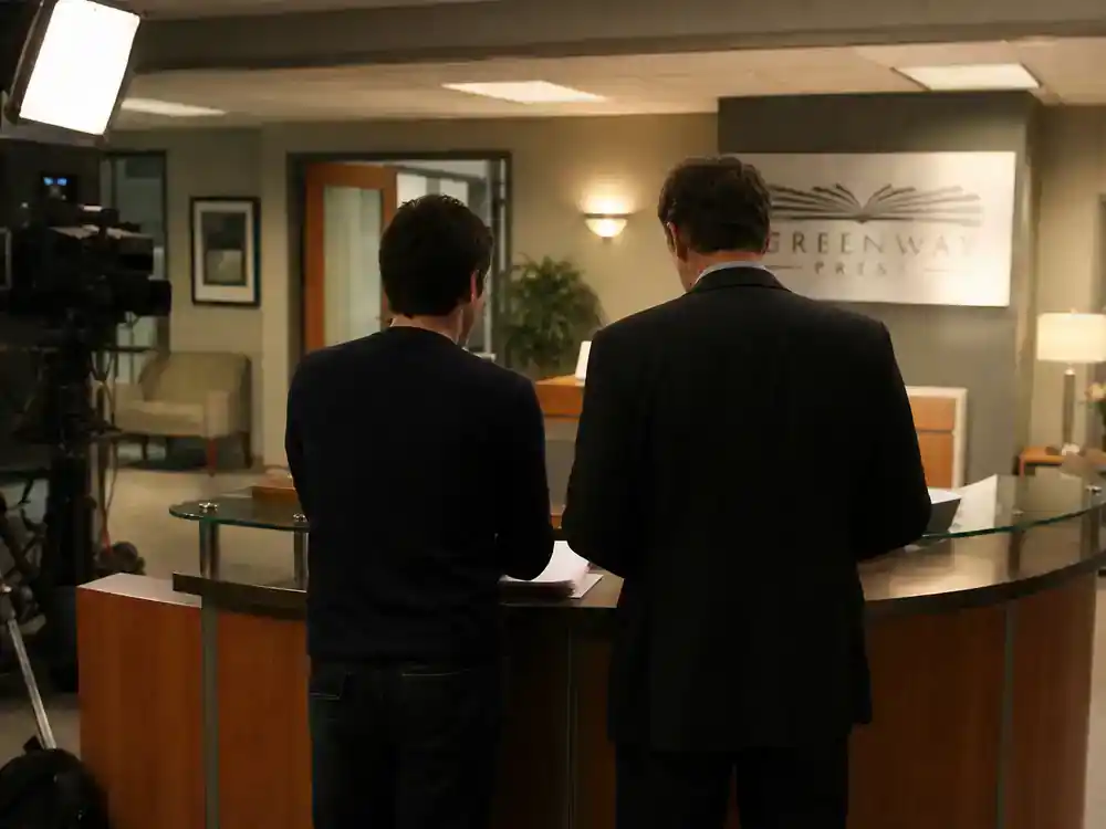 The Office cast net worth 2026 ranked Jenna Fischer Pam Beesly — two actor silhouettes rehearsing at reception desk on office TV set