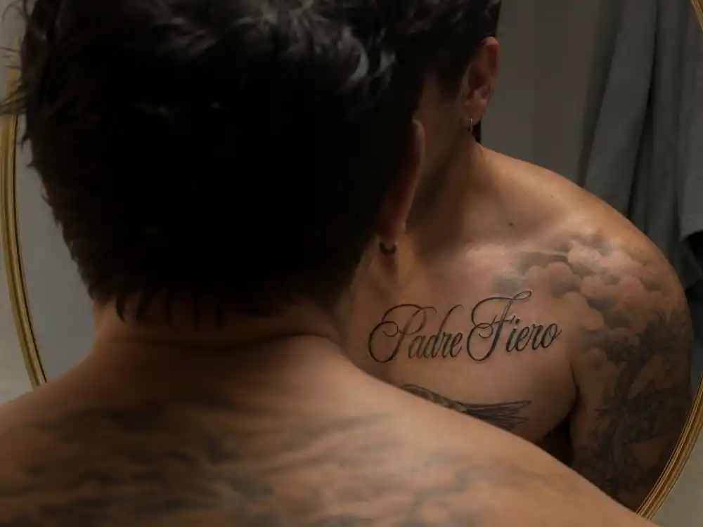Tom Hardy tattoos and their meanings — Padre Fiero Italian proud father script on collarbone mirror reflection
