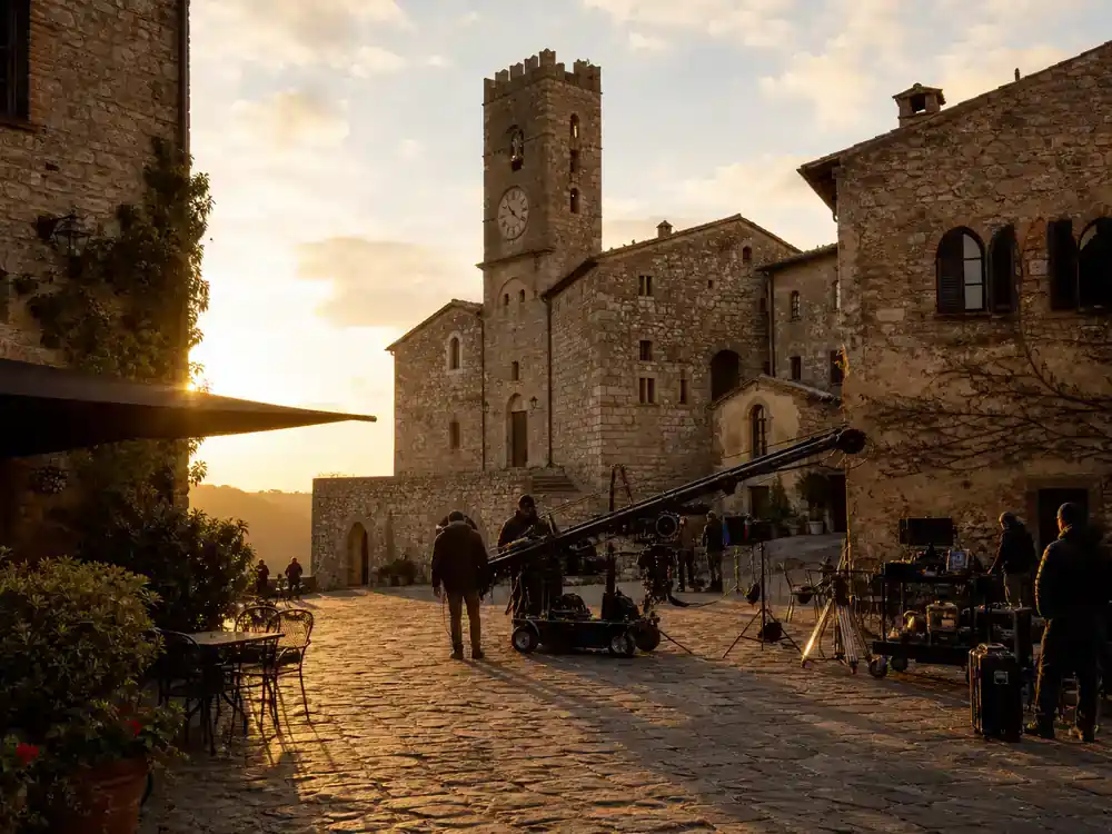 Twilight movies filming locations guide Italy Volterra — historic hill town cobblestone plaza with film crew and camera crane among medieval stone buildings