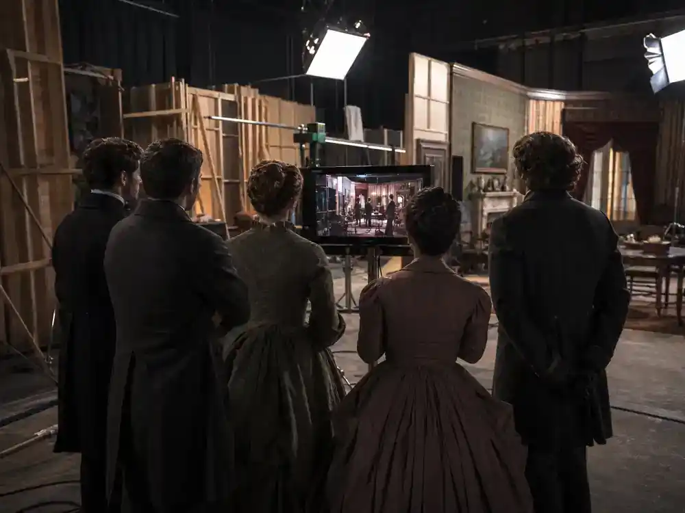 Wuthering Heights Margot Robbie movie cast guide supporting cast — ensemble silhouettes in Victorian costumes blocking scene on period drama soundstage