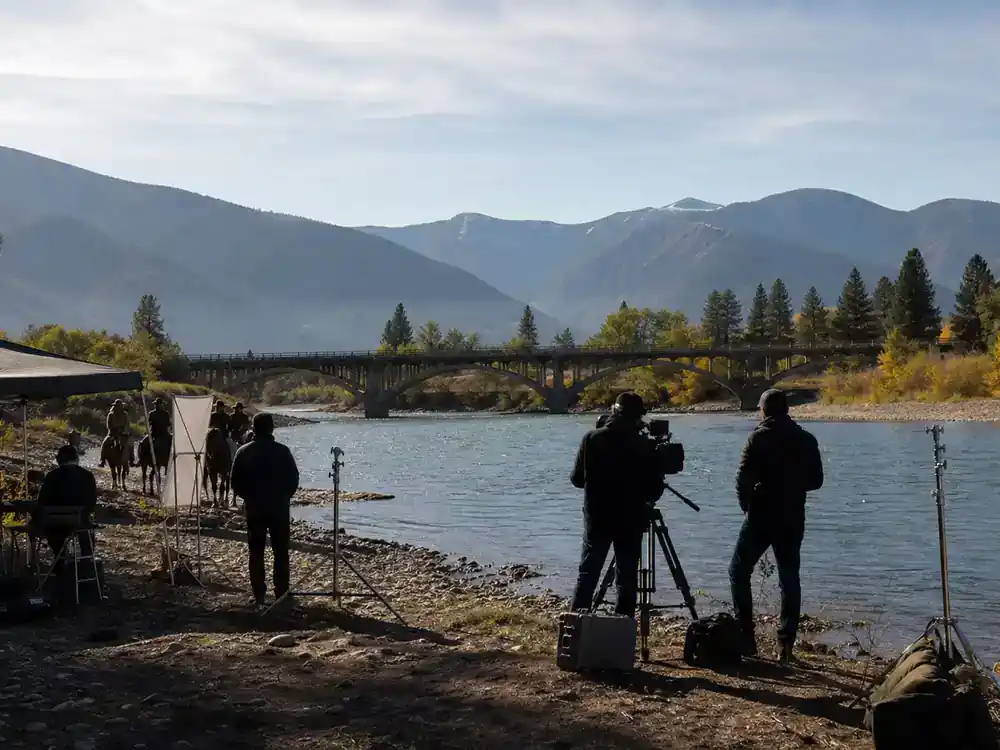 Yellowstone filming locations Montana guide Missoula — river valley filming location with bridge film crew silhouettes and Montana mountain skyline