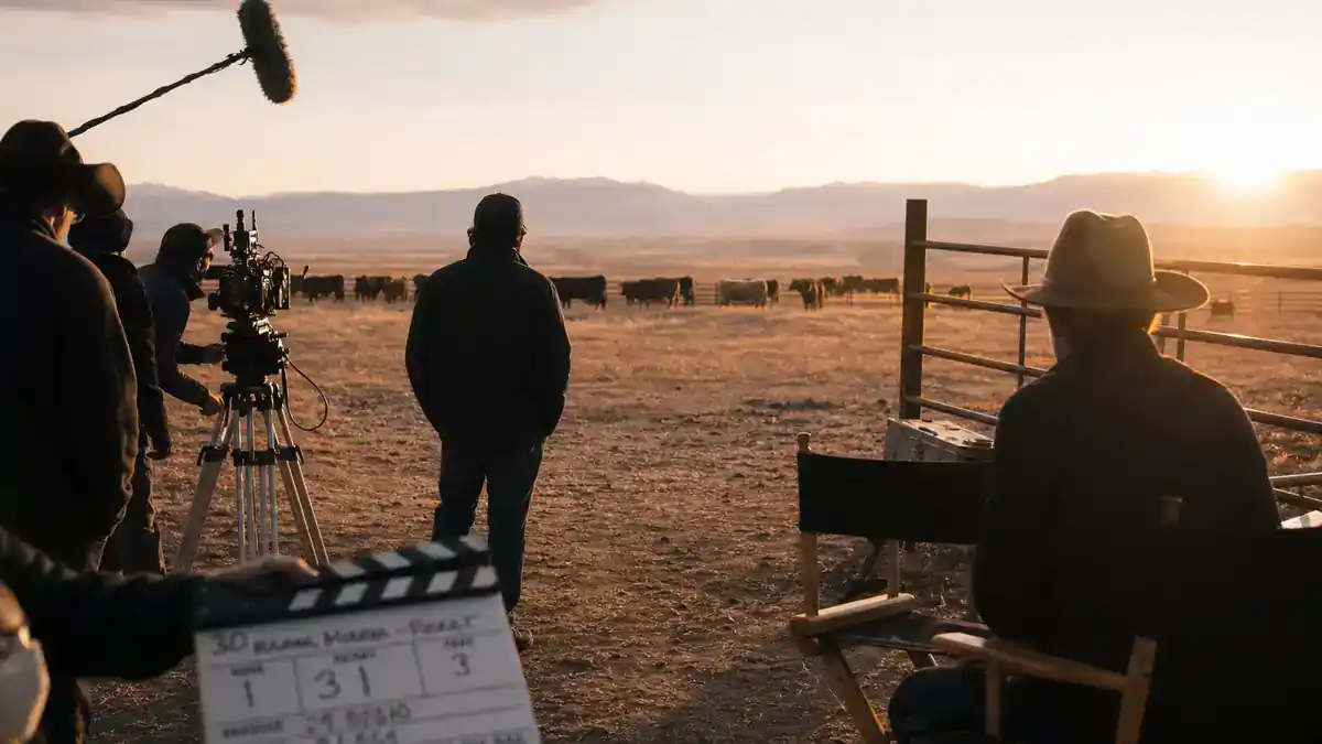 Yellowstone spinoff 2026 cast and timeline guide — western TV drama production on Montana ranch film set with clapperboard director chairs and crew silhouettes at golden hour