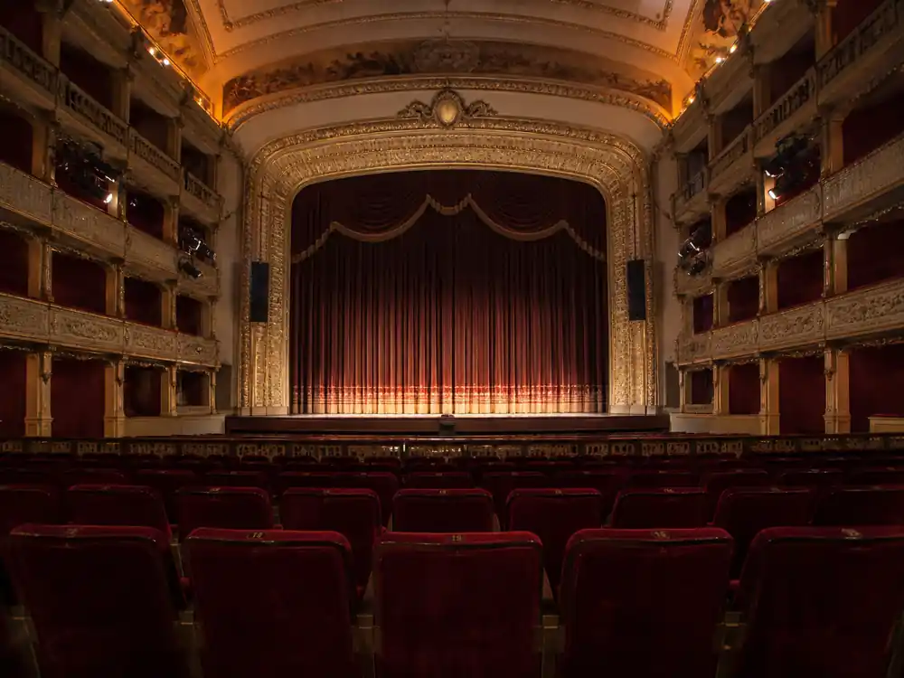Empty theatre seats framing the live work behind Adele net worth 2026