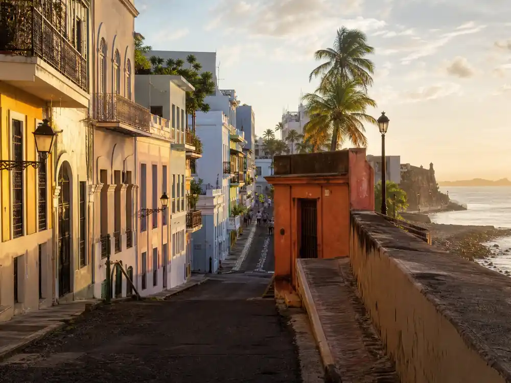 Colorful coastal urban street at golden hour in Puerto Rico, tied to the residency year in Bad Bunny net worth 2026