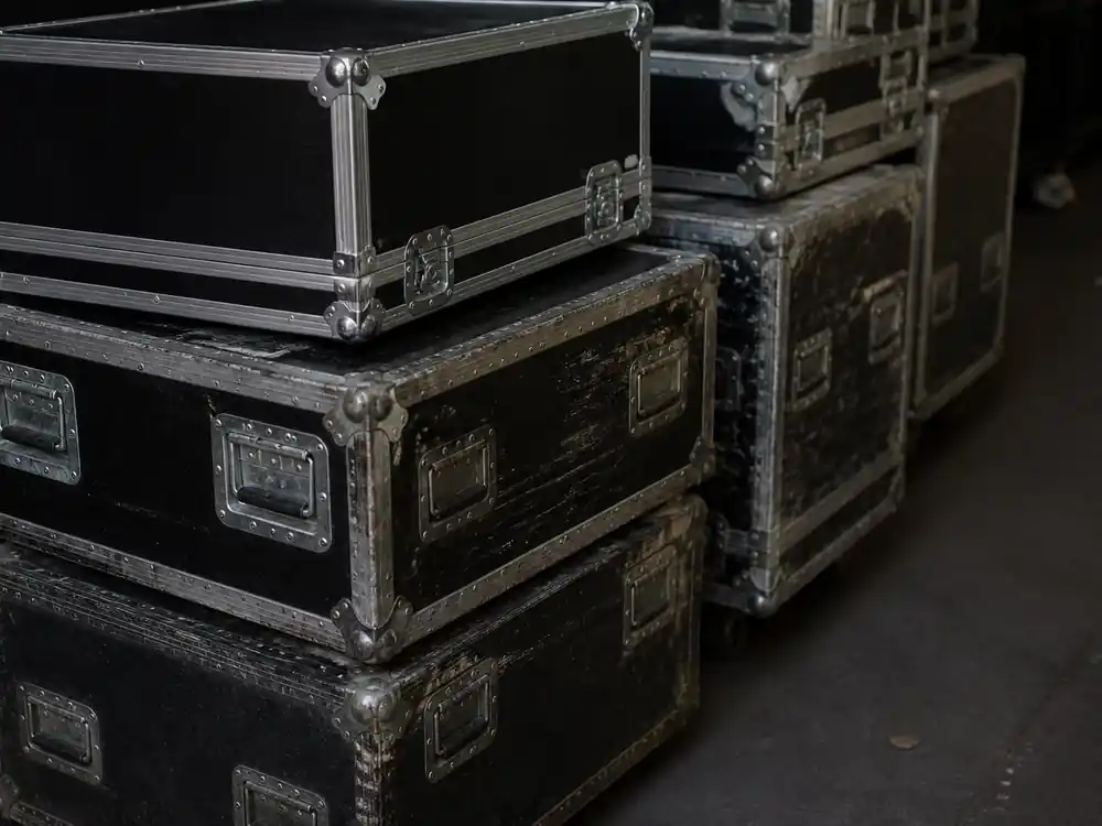 Unmarked tour road cases showing different wear levels across years of Bad Bunny net worth over the years