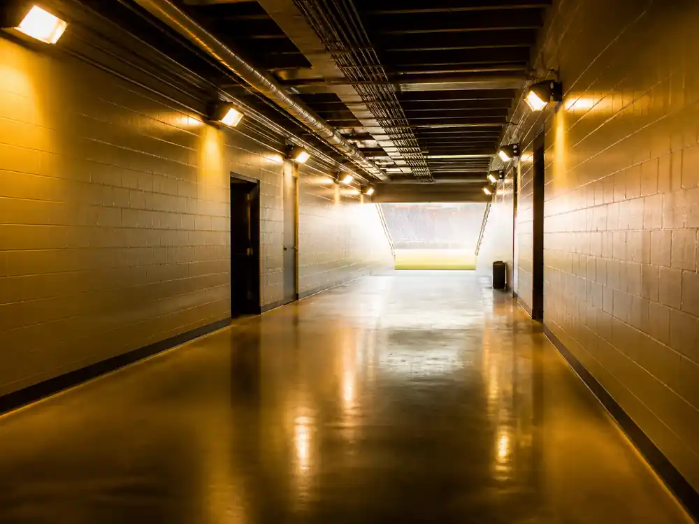 Empty stadium tunnel with warm gold light, the 24K Magic touring scale behind Bruno Mars net worth 2026