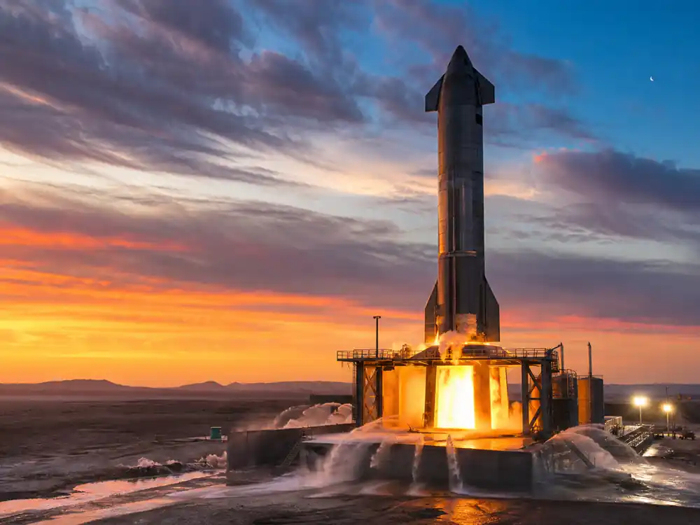 Rocket on static-fire test pad at dusk tied to Elon Musk net worth 2026 SpaceX public listing