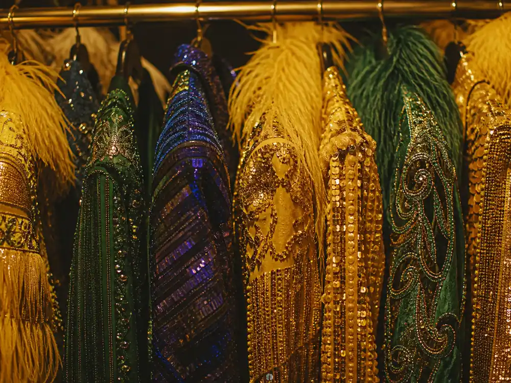 Sequin performance jackets on wardrobe rail for Elton John net worth 2026 stage wealth