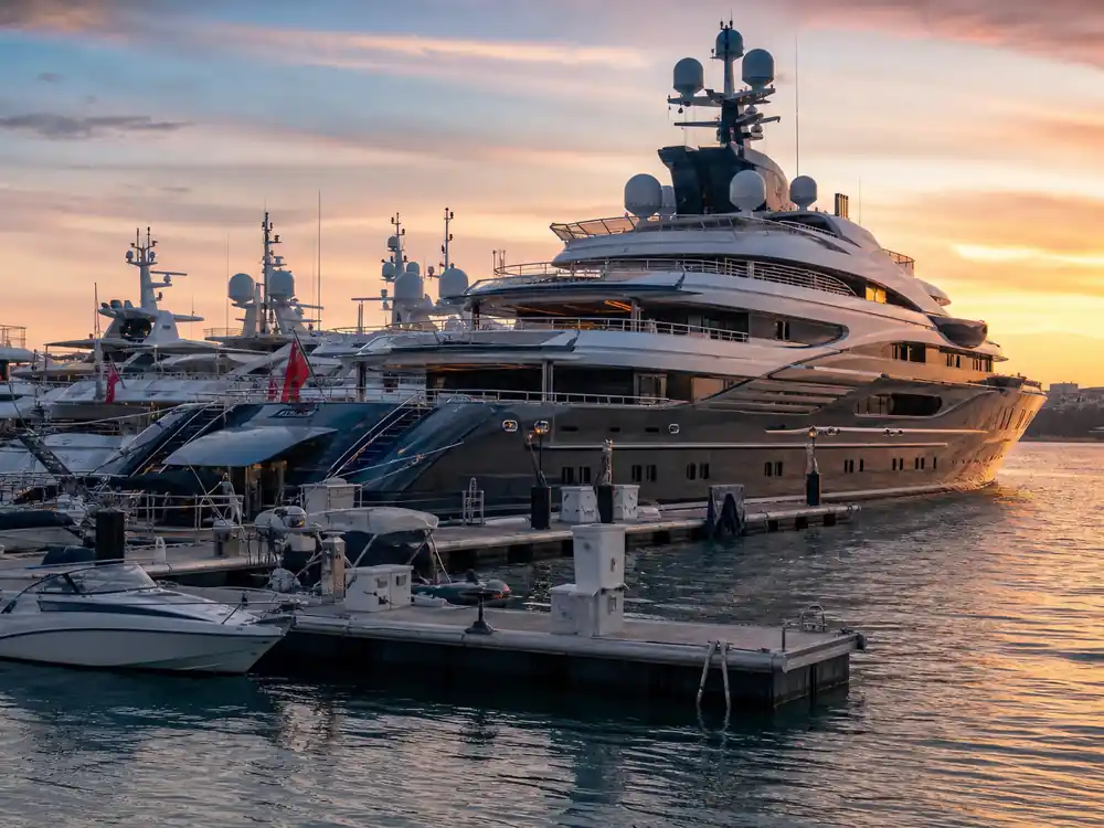 Marina with yachts of different sizes at dusk, a wealth-scale contrast for how much is Bad Bunny worth