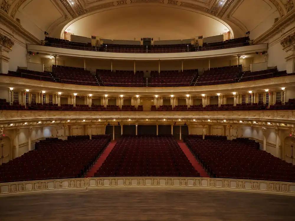 Empty symphony hall tiered seating, a ranking metaphor for how much is Billie Eilish worth among pop peers