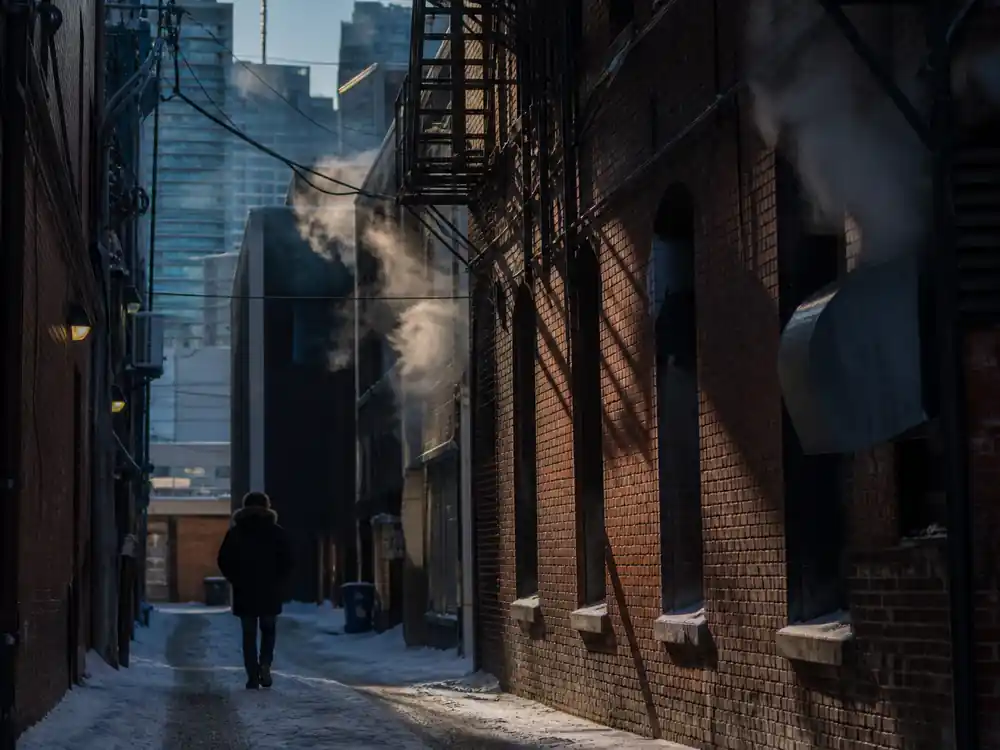 Winter Toronto alley with distant figure for how much is Drake worth comparison context