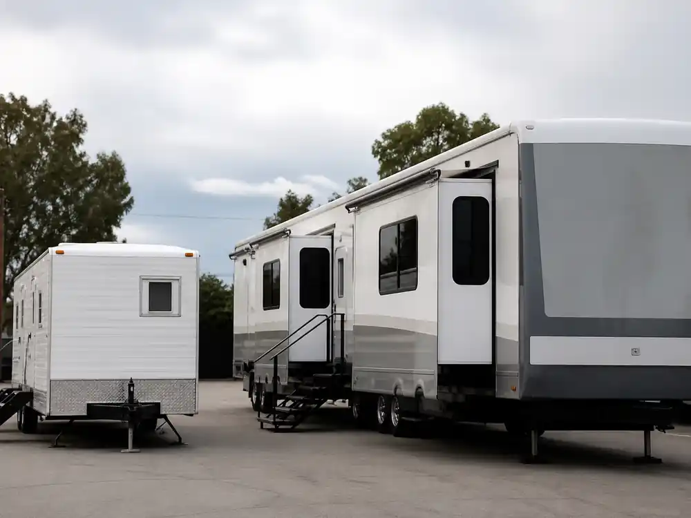 Two empty production trailers in size contrast reflecting how much is Dwayne Johnson worth next to Vin Diesel